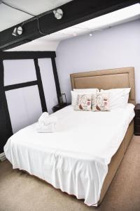 Wooburn老贝尔宾馆的一间卧室配有一张带白色床单的大床