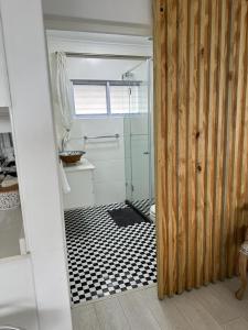乌姆德洛蒂514 Umdloti Resort Spectacular breakers view的带淋浴的浴室以及黑白瓷砖地板。