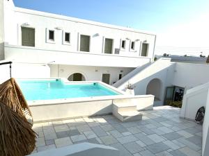 安迪帕罗斯岛阿特米斯酒店的白色建筑前的游泳池