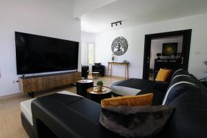 阿尔豪林德拉托里TESS Villa Jocalo的客厅配有黑色沙发和平面电视。