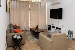 卢萨卡Urban oasis in kingsland city的客厅配有2把椅子和平面电视