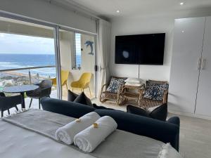 乌姆德洛蒂514 Umdloti Resort Spectacular breakers view的一间带蓝色沙发的卧室,享有海景
