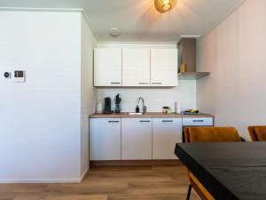 斯内克Modern renovated apartment in the heart of Sneek的厨房配有白色橱柜和桌椅