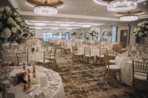 欧文The Gailes Hotel & Spa的宴会厅配有白色的桌椅和吊灯。