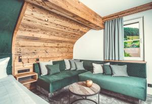 上施陶芬Hotel Alpenkönig的客厅设有绿色沙发和木墙