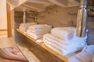 利维尼奥Bait da Menego的浴室架子上的一大堆毛巾