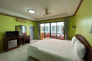 奥南海滩Me Mee Place & Tour Krabi的一间卧室配有一张床、一台电视和一个阳台
