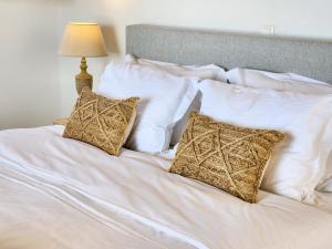 阿吉亚艾里尼帕罗Anthemion Paros - Villas & Suites的白色的床、白色枕头和灯