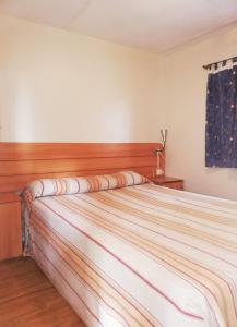 卡塔赫纳Camping Naturista El Portús - Nudist FKK的一间卧室配有一张大床和木制床头板