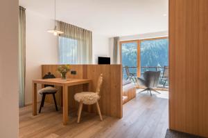 圣克里斯蒂娜Vista Dolomites Apartment Liberty的配有桌子、两把椅子和一张书桌的房间