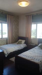 拉纳卡Quattro Sea View Beachfront Ap 6的带2扇窗户的客房内的2张床