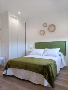 欧德鲁佐Pensión Os Mollados的一间卧室配有一张大床和绿色床头板