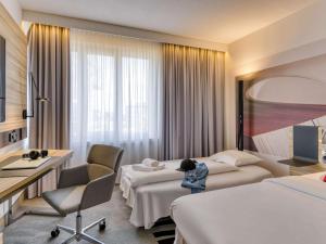科隆科隆诺沃特酒店的酒店客房配有两张床和一张书桌