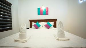 贾夫纳JAMUNA VILLA的一间卧室配有一张带两条白色毛巾的床