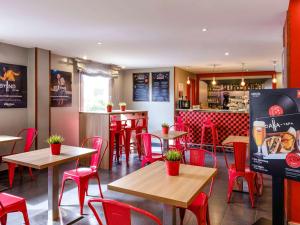 阿尔考空宜必思马德里阿尔科尔孔崔萨瓜斯酒店的一间设有红色桌椅的餐厅和一间酒吧