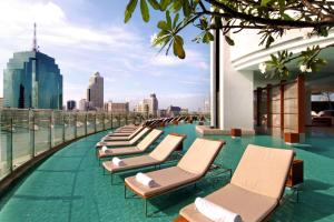 曼谷曼谷千禧希爾頓酒店 的建筑物屋顶上的一排躺椅