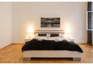 维也纳Deluxe 3BR Apt. Wiener Stadthalle - Suitable for Longstays的一间卧室配有一张带两盏灯的大型白色床。