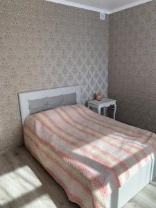 雷泽克内VILLA ROZA Guest House的一间卧室配有一张带红白毯子的床