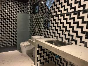 蔻立Grandfather Khaolak Resort的黑白浴室设有水槽和卫生间
