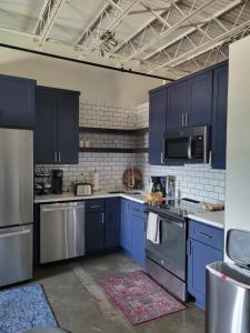 韦科Silo View - heart of downtown的厨房配有蓝色橱柜和不锈钢用具