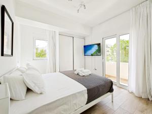 雅典Marathonomachon Apartments by Verde Apartments的白色卧室设有大床和窗户