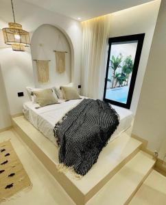 乌姆苏克Dar Oliva Maison de luxe的一间卧室配有一张带黑白毯子的床