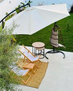 乌姆苏克Dar Oliva Maison de luxe的白色遮阳伞下的桌椅