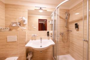 布拉格Hotel Meteor Plaza Prague的一间带水槽和淋浴的浴室
