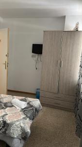 阿利坎特pensión La Parada的一间卧室配有一张床和一个木制橱柜