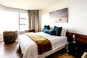 赫曼努斯Bayview 208的一间卧室配有一张带蓝色枕头的大床