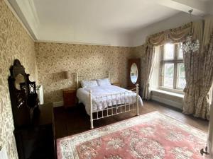 彼得伯勒Thornhaugh Old Rectory的一间卧室设有一张床和一个大窗户