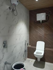 孟买Hotel Palms Residency, Chembur Mumbai的浴室配有白色卫生间和淋浴。