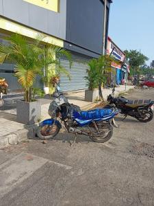 孟买Hotel Palms Residency, Chembur Mumbai的两辆摩托车停在大楼前的停车场