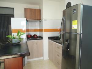 内瓦APARTA-ESTUDIO LA TOMA的厨房配有不锈钢冰箱和木制橱柜