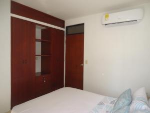 内瓦APARTA-ESTUDIO LA TOMA的一间卧室配有一张床和一个衣柜