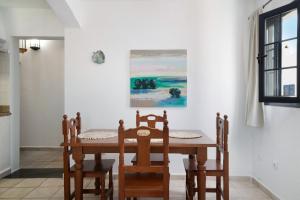 塞博河畔卡莱塔Apartamento Cabo的一间带桌椅和绘画的用餐室