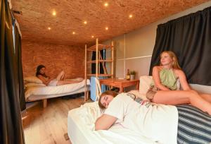 特拉维夫Caravan Hostel Tel Aviv By Roger Age 18-45的三个女孩躺在房间里的床上