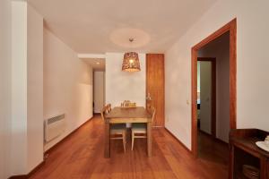 阿尔普Hauzify I Apartament Bella Molina的用餐室配有木桌和灯具