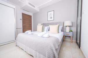 KoubaAppartement Luxueux à Kouba的白色卧室配有一张带白色枕头的大床