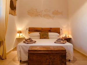 卡洛福泰Guest House Calalunga Scogliera的一间卧室配有一张带木制床头板的床和两盏灯。