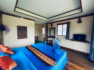 库德岛Markhouse Bungalow Ko Kut的一间卧室配有蓝色的床和蓝色的毯子