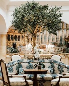 塞哥维亚坎迪多酒店的一间拥有树木和桌椅的房间