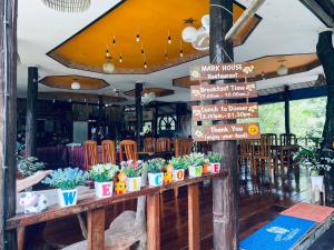 库德岛Markhouse Bungalow Ko Kut的餐桌上摆放着标志和植物的餐厅