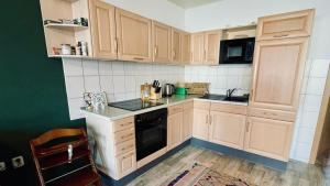 艾本施托克Ferienwohnung Ida Pfeiffer的厨房配有木制橱柜和黑色用具