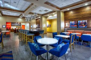 哥伦比亚哥伦比亚/杰克逊堡东南部汉普顿酒店的一间设有蓝色桌椅的餐厅和一间酒吧