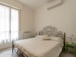 阿拉西奥Apartment Sant'Antonio by Interhome的白色卧室配有一张带金属床头板的大床