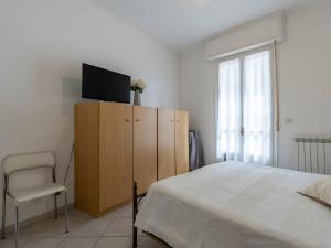阿拉西奥Apartment Sant'Antonio by Interhome的一间卧室配有一张床,并在橱柜上配有电视