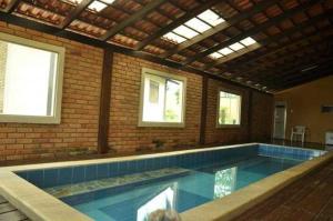 沙帕达-杜斯吉马朗伊斯POUSADA PEQUIZEIRO的一座大型游泳池,位于一座带窗户的建筑内