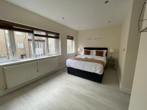 伦敦Islington Town House的一间卧室设有一张大床和两个窗户。