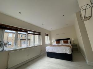 伦敦Islington Town House的一间卧室设有一张大床和两个窗户。